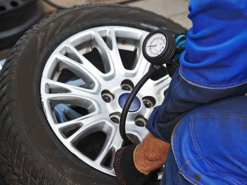 Checking tyre pressure with a gauge.