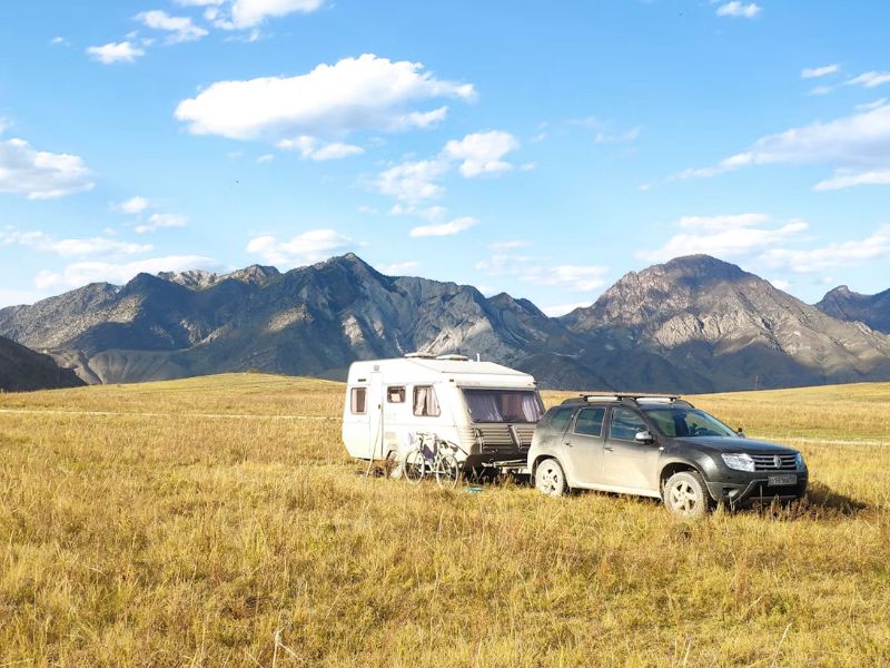 Touring caravan being towed by a car.